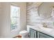 Charming half bathroom with shiplap accent wall, modern vanity with quartz countertop, and natural light from the window at 9237 Rocky Cay Ct, Zionsville, IN 46077