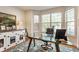 Bright home office features a glass desk, large windows, and custom cabinetry with a pet kennel at 9237 Rocky Cay Ct, Zionsville, IN 46077