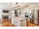 Elegant kitchen featuring a large island, stainless steel appliances, and a cozy fireplace, creating a perfect blend of style and functionality at 9237 Rocky Cay Ct, Zionsville, IN 46077