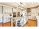 Spacious kitchen featuring an island with stone countertop and seating, complemented by white cabinetry and modern lighting at 9237 Rocky Cay Ct, Zionsville, IN 46077