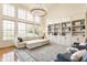Bright living room with soaring ceilings, large windows, built-in shelving, and comfortable seating, creating an inviting atmosphere at 9237 Rocky Cay Ct, Zionsville, IN 46077