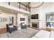 Comfortable living room featuring a stone fireplace, mounted tv, soaring ceilings, and views to the 2nd level at 9237 Rocky Cay Ct, Zionsville, IN 46077