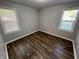 Bright, minimalist bedroom with two windows and hardwood-style floors at 937 N Routiers Ave, Indianapolis, IN 46219