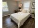 A well-lit bedroom with a comfortable-looking bed and wood flooring at 937 N Routiers Ave, Indianapolis, IN 46219
