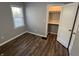 Bedroom with wood floors and a closet with shelving, filled with natural light at 937 N Routiers Ave, Indianapolis, IN 46219