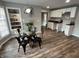 Dining area open to kitchen, featuring modern table, lighting, and hardwood floors at 937 N Routiers Ave, Indianapolis, IN 46219