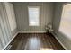 A view of the room with wood flooring, two windows, a storage closet and a decorative plant in the corner at 937 N Routiers Ave, Indianapolis, IN 46219