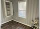 A view of the room with wood flooring, one window and a small storage closet with shelves at 937 N Routiers Ave, Indianapolis, IN 46219