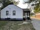 A view of a two story home with white siding, black trim, gravel driveway and minimal landscaping at 937 N Routiers Ave, Indianapolis, IN 46219