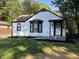 Charming cottage-style home featuring white siding, black trim, and bay windows at 937 N Routiers Ave, Indianapolis, IN 46219