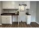 A modern, well-lit kitchen with white cabinets and wood-style flooring at 937 N Routiers Ave, Indianapolis, IN 46219