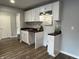 Bright kitchenette area with white cabinets, dark countertop, and wood floors at 937 N Routiers Ave, Indianapolis, IN 46219