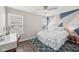 Stylish bedroom featuring a geometric accent wall, ceiling fan, and a cozy desk area at 9707 Prairie Smoke Dr, Noblesville, IN 46060