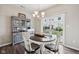 Cozy dining area with a round wood table, chandelier, and sliding door to the backyard at 9707 Prairie Smoke Dr, Noblesville, IN 46060