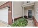 Close-up of the townhome's entryway with a well-manicured garden and a charming porch at 9707 Prairie Smoke Dr, Noblesville, IN 46060