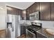 Stylish kitchen features stainless steel appliances, dark wood cabinets, and granite counters at 9707 Prairie Smoke Dr, Noblesville, IN 46060