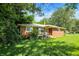 View of a single story brick home with overgrown landscaping and grass on a sunny day at 10159 Hodge Rd, Clayton, IN 46118
