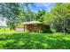 A rear exterior side view of a brick home surrounded by green grass and trees at 10159 Hodge Rd, Clayton, IN 46118