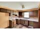 Traditional kitchen area with dark cabinets, double sink, and a window for natural light at 10159 Hodge Rd, Clayton, IN 46118