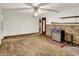 Basic living room with a ceiling fan, wood look wall paneling, and an entrance to another room at 10159 Hodge Rd, Clayton, IN 46118