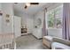 Neutral bedroom features a window with curtains, a dresser, and a chair at 1105 Windsor St, Indianapolis, IN 46201