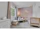 Serene bedroom features soft, patterned wallpaper, chair, crib, and plush carpeting at 1105 Windsor St, Indianapolis, IN 46201