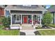 Two-story home featuring a welcoming front porch with white columns and colorful landscaping at 1105 Windsor St, Indianapolis, IN 46201