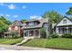 Traditional two-story home with a covered porch, red door, and lush green lawn at 1105 Windsor St, Indianapolis, IN 46201