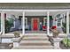 Inviting front porch with white columns, a bench, chairs, and decorative hanging plants at 1105 Windsor St, Indianapolis, IN 46201