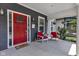 Charming front porch with a vibrant red door, cozy chairs, and meticulous landscaping at 1105 Windsor St, Indianapolis, IN 46201