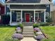 Inviting front porch with a red door, white columns, seating, and manicured landscaping at 1105 Windsor St, Indianapolis, IN 46201