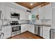 Bright and modern kitchen featuring white cabinets, stainless steel appliances, and wood-look ceiling at 1105 Windsor St, Indianapolis, IN 46201