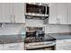 Close up of a stainless steel stovetop and microwave inside of a renovated kitchen at 1105 Windsor St, Indianapolis, IN 46201