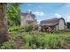 Spacious backyard features a grassy area, small trees, and a wood pile at 1129 Trowbridge St, Indianapolis, IN 46203