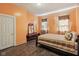 Bedroom with orange walls, wood floors, and ornate dark wood bed at 1129 Trowbridge St, Indianapolis, IN 46203