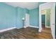 Bedroom with teal walls, wood floors, and white trim, door open at 1129 Trowbridge St, Indianapolis, IN 46203
