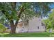 Side view of a two-story home with a covered porch, surrounded by mature trees and a well-kept lawn at 1129 Trowbridge St, Indianapolis, IN 46203