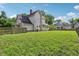 View of the house from the expansive green backyard, surrounded by a wooden fence at 1129 Trowbridge St, Indianapolis, IN 46203