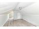 Attic features neutral carpet, slanted ceilings, closet, window, and light fixture at 114 South St, Southport, IN 46227