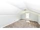 Attic features neutral carpet, slanted ceilings, one window, and light fixture at 114 South St, Southport, IN 46227
