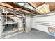 Unfinished basement featuring utilities, exposed ceiling, and painted walls with shelving for storage at 114 South St, Southport, IN 46227