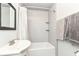 Bathroom features tiled shower, tub, and sink with white color palette and storage shelves at 114 South St, Southport, IN 46227