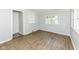 Bedroom with blue walls, a wood-look laminate flooring, and natural light from the windows at 114 South St, Southport, IN 46227