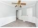 Bright bedroom with wainscoting, ceiling fan, and easy access to other rooms at 114 South St, Southport, IN 46227