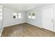 Bedroom with blue walls and laminate flooring, brightened by the natural light of two windows at 114 South St, Southport, IN 46227