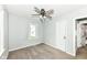 Carpeted bedroom with a ceiling fan offers a window view and easy access to the bathroom at 114 South St, Southport, IN 46227