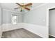 Charming bedroom featuring a ceiling fan, wainscoting, and a window view at 114 South St, Southport, IN 46227