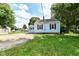 Charming blue house with red shutters and well-manicured lawn at 114 South St, Southport, IN 46227