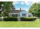 Charming blue home with red shutters and a well-manicured lawn at 114 South St, Southport, IN 46227