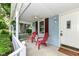 Cozy front porch with white columns and inviting red Adirondack chairs at 114 South St, Southport, IN 46227